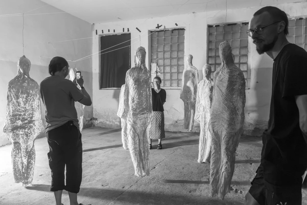 Visitors to the “Aritmija” festival among the figures of the “Shells” installation in the Merkinė sawmill