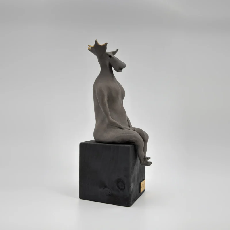 Sculpture "Dignity", seated figure with moose antlers, side view